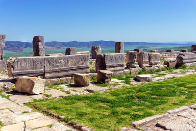 Old ruins by sea against blue sky