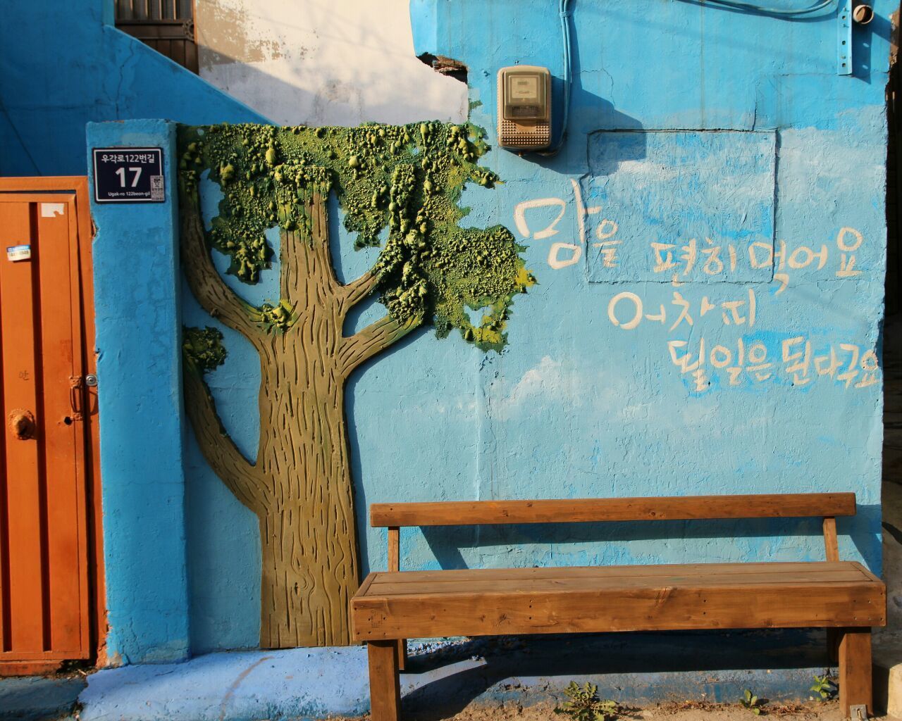 built structure, architecture, wall - building feature, building exterior, graffiti, wall, text, door, blue, house, day, plant, communication, no people, outdoors, western script, potted plant, closed, sunlight, old