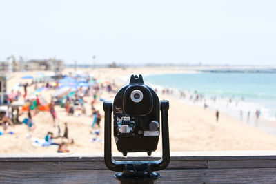 Close-up of coin-operated binoculars against beach