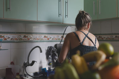 Caucasian woman with her back to her cooking in the kitchen. 