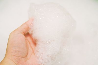 Close-up of hand touching water in bathroom