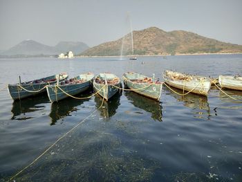 Boats moored on sea against clear sky