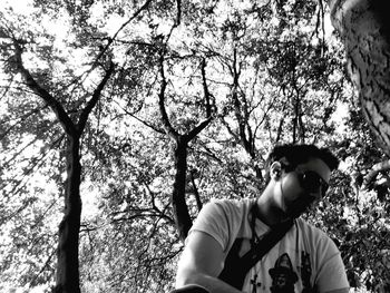 Low angle view of man standing against trees