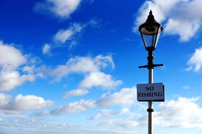 Low angle view of street light against blue sky