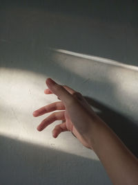 Close-up of hand touching wall