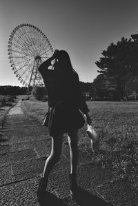 Woman standing on field against clear sky