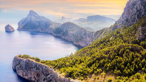 Scenic view of sea and mountains against sky