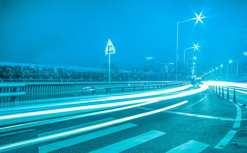 Light trails on road against sky at night