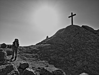 Low angle view of cross on rock against sky