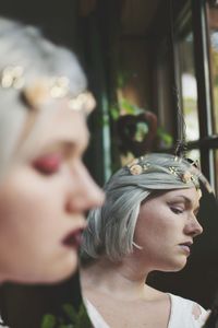 Close-up reflection of spooky woman looking away in mirror