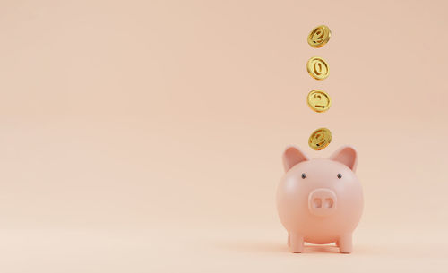 Directly above shot of piggy bank on pink background