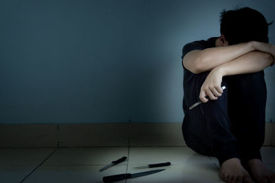 Man sitting on wall at home