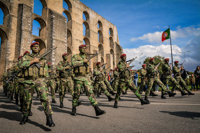 People in front of flags against sky