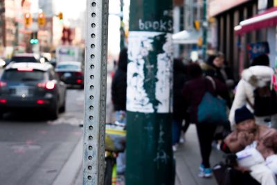 Metallic pole on sidewalk in city
