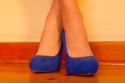 Low section of woman standing on hardwood floor