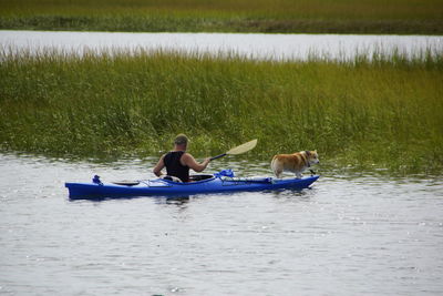 Man kayaking with dog