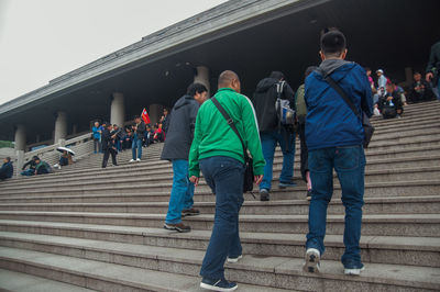 Rear view of people walking on staircase