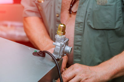 Midsection of man working on metal in workshop