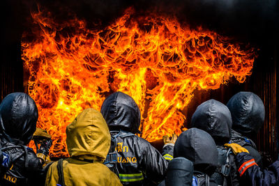 Rear view of firefighters extinguishing fire