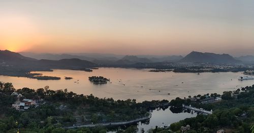 High angle view of sea and mountains against sky during sunset