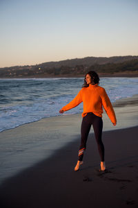 A woman appreciates the sunset along the coast