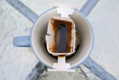 Top view of a cup of aromatic portable drip coffee being prepared on the outdoor table