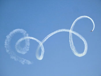 Low angle view of airplane flying against blue sky