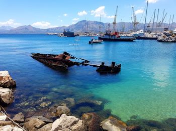 Sailboats moored on sea against sky