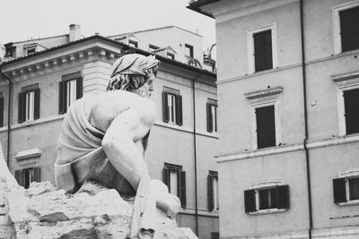 Low angle view of statue against building in city