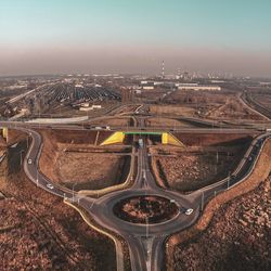 High angle view of highway amidst field against sky