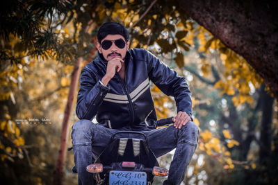 Man wearing sunglasses against trees during autumn