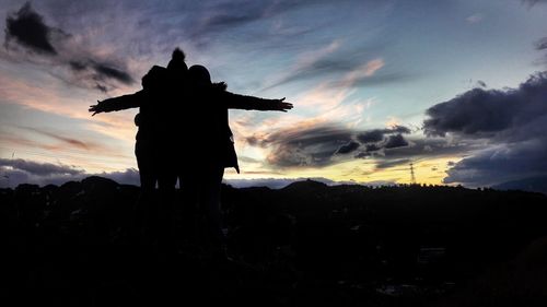 Low angle view of silhouette statue against dramatic sky