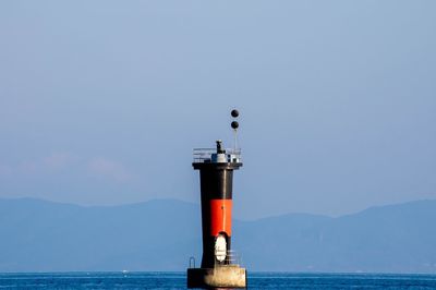 Beacon in sea against sky