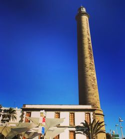 Low angle view of communications tower against blue sky