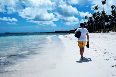 Rear view of man walking on beach