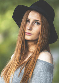 Portrait of young woman with long hair wearing hat