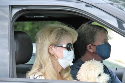 Portrait of young  couple  in car wearing masks