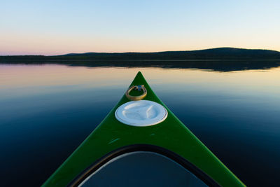 Close-up of boat floating on lake against sky