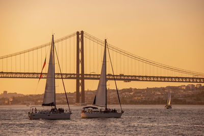 Suspension bridge over sea against clear sky