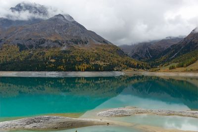 Scenic view of lake by mountains against sky