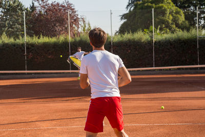 Men playing tennis in court