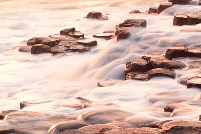 Rocks on shore at sunset