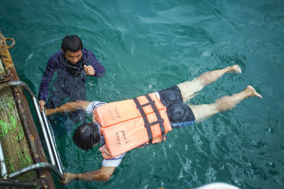 High angle view of men swimming in sea