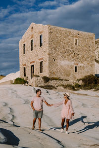 People on cobblestone street amidst buildings