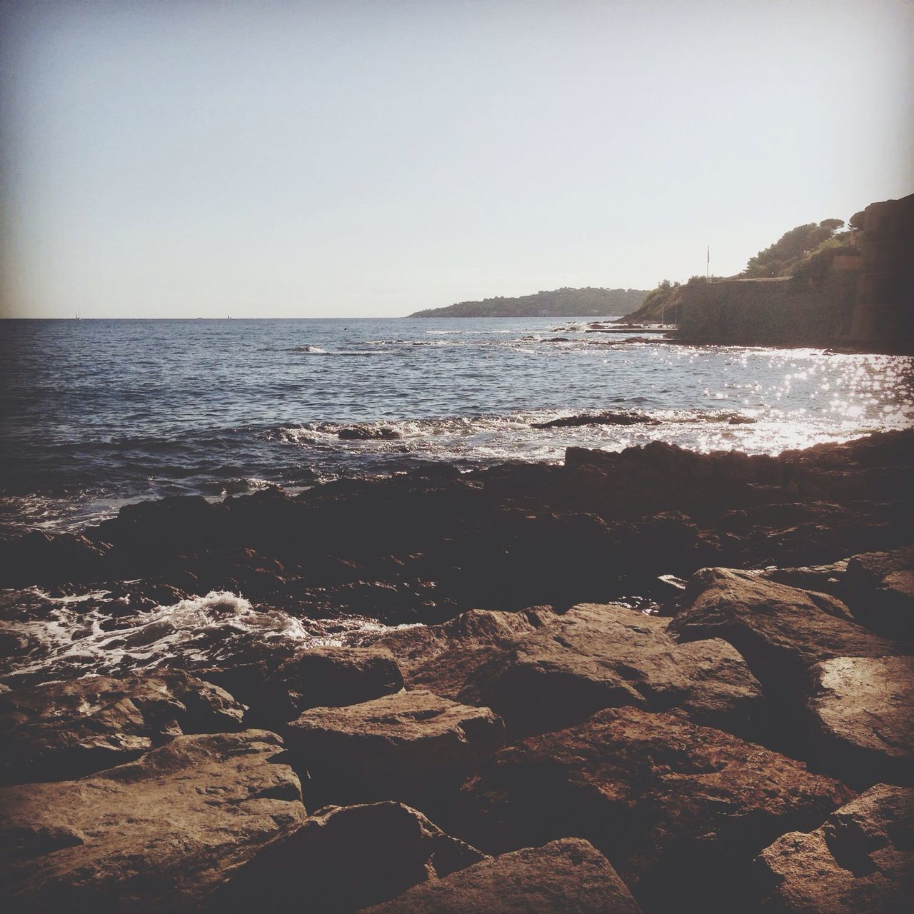 water, sea, clear sky, beach, tranquil scene, tranquility, scenics, shore, horizon over water, beauty in nature, rock - object, nature, copy space, sky, idyllic, sunlight, sand, coastline, wave, remote