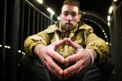 Portrait of man sitting in illuminated room