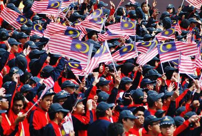 People with malaysian flags during celebration