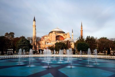 Water fountain and hagia sophia against sky