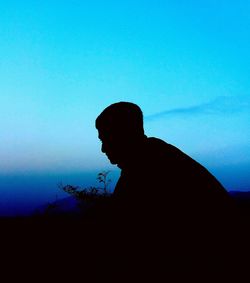 Silhouette man against blue sky
