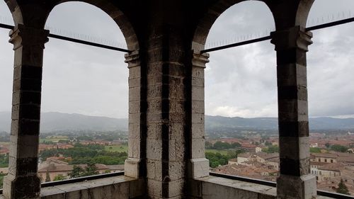 Old buildings against sky seen through window